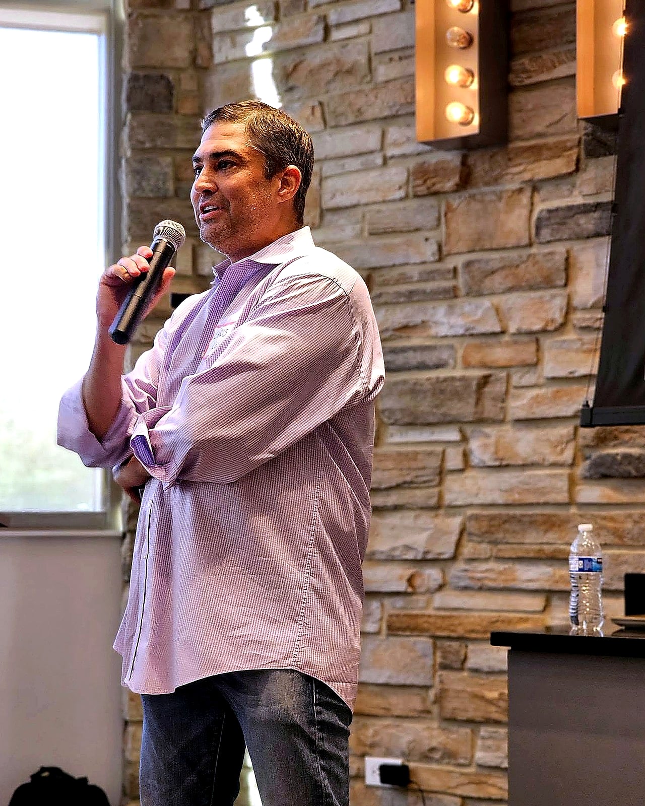Chris Kovac speaking into a microphone at a live event