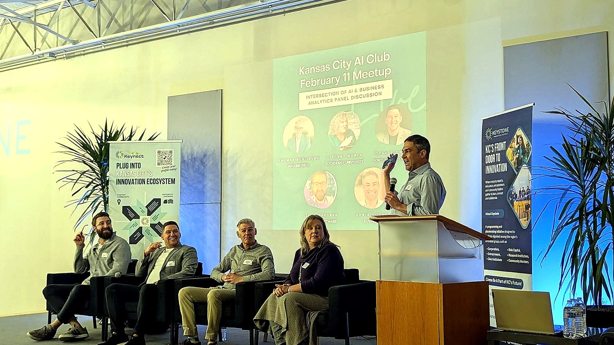 Chris Kovac at the podium hosting a Kansas City AI Club panel discussion